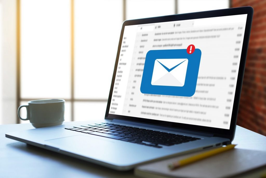 Notebook com ícone de e-mail na tela, representando a estrategia de e-mail marketing no artigo "O que é marketing digital?"