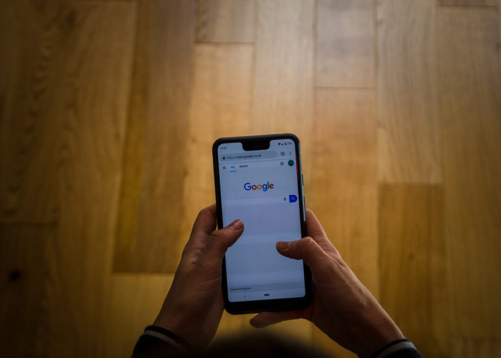 mão de mulher usando o google no smartphone para pesquisar algo