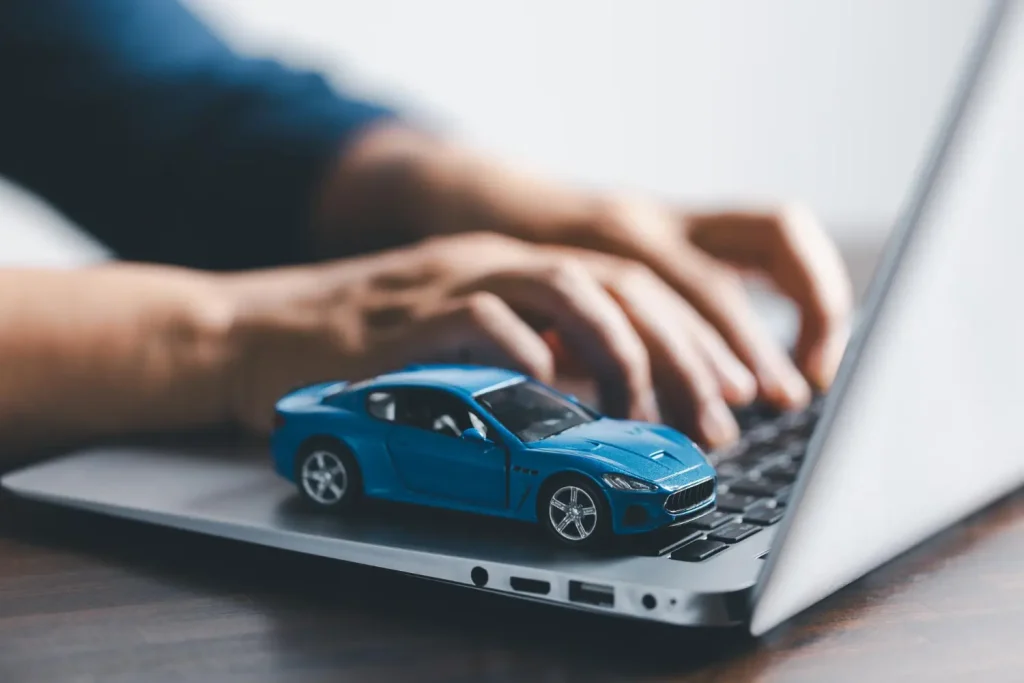 Funcionalidades do CRM automotivo Miniatura de carro sobre laptop representando as funcionalidades do CRM automotivo