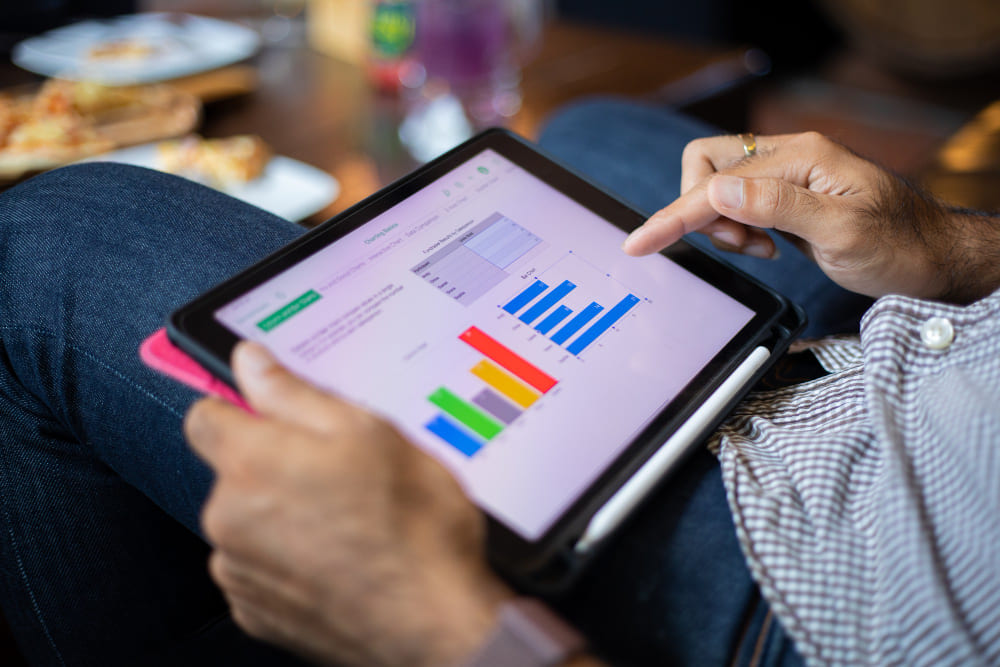 mãos mexendo em um tablet para fazer pesquisa de mercado